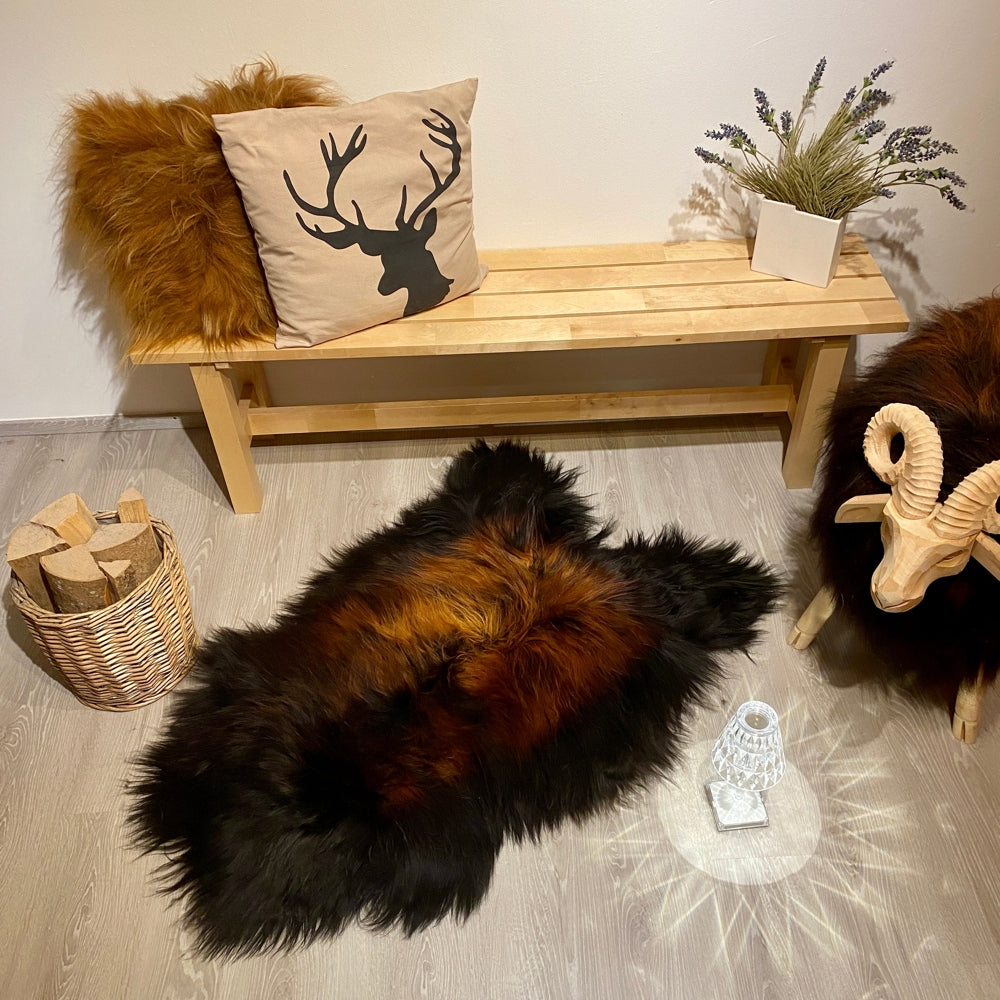 Isländisches Schaffell in Schwarz und Goldbraun – natürliche Einzelstückfelle mit charaktervoller Färbung. Großzügiges Format (120x80cm) für Sofa, Bett oder als Statement-Piece. Authentische Textur und wärmende Qualität für zeitlose Wohnkultur.